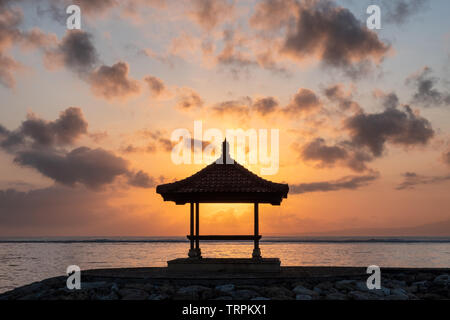 Sunshine nel padiglione sul molo al litorale in mattina. Spiaggia di Sanur, Bali Foto Stock