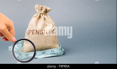 Sacco di denaro con la parola di pensione e di misura di nastro. Autunno / riduzione dei pagamenti pensionistici. Il pensionamento. Finanziamento pensionati. Riduzione del fondo pensione. Th Foto Stock
