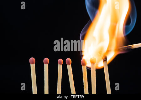 Linea di partite di masterizzazione su sfondo nero Foto Stock