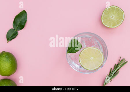 Il gin tonic cocktail drink in vetro su estate sfondo rosa Foto Stock