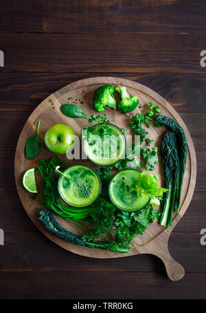 Vista aerea del fresco succo verde al buio su un superficie di legno con spazio di copia Foto Stock
