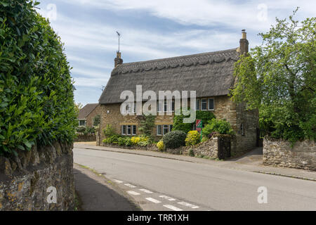 Costruita in pietra con il tetto di paglia, periodo proprietà nel villaggio di Milton Malsor, Northamptonshire, Regno Unito Foto Stock