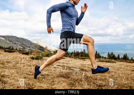 Uomo che corre atleta eseguire il sentiero di montagna vista laterale Foto Stock