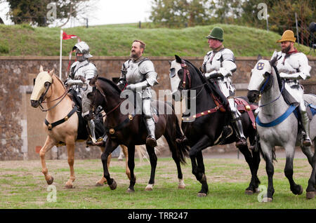 Quattro cavalieri in armatura completa dimostrando la loro equitazione abilità, durante un patrimonio Inglese giostre del torneo al castello di Dover, Agosto 201 Foto Stock