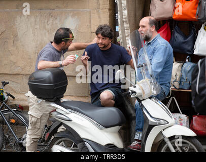 Tre uomini tenuto nel centro di Firenze, Italia Foto Stock