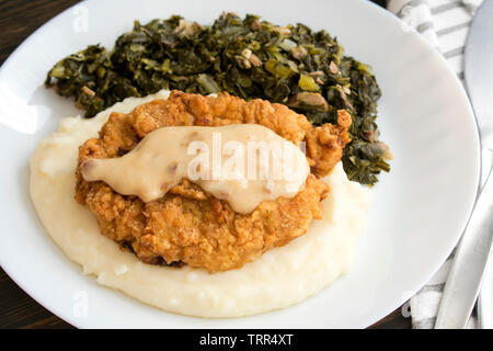Chicken Fried Steak e sugo di carne con purè di patate e Collard verdi Foto Stock