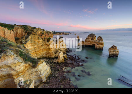 Un paesaggio fantastico a sunrise. Bellissima spiaggia vicino a Lagos in Ponta da Piedade, regione di Algarve, Portogallo. Seascape con Cciff rocce. Foto Stock