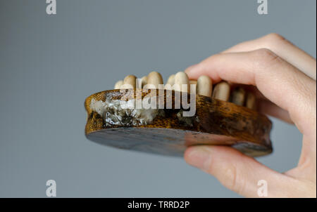 Disgustoso il fungo della donna in legno spazzola per massaggi. Close up. Per la pulizia della casa del concetto. Foto Stock
