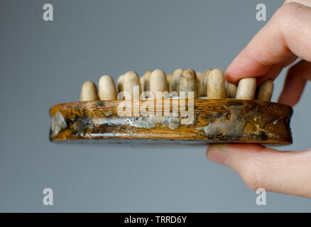 Disgustoso il fungo della donna in legno spazzola per massaggi. Close up. Per la pulizia della casa del concetto. Foto Stock