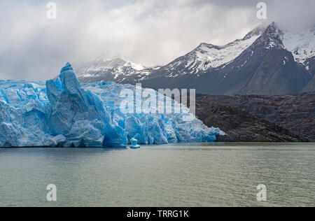 Il blue ice ghiacciaio Grey con picchi andini nella neve dal grigio Lago, Parco nazionale di Torres del Paine nella Patagonia cilena. Foto Stock