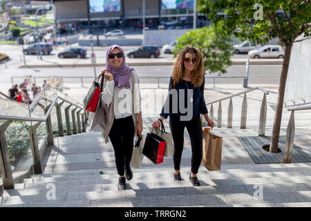 Due belle ragazze con borse per lo shopping a piedi su per le scale nel cuore della città Foto Stock