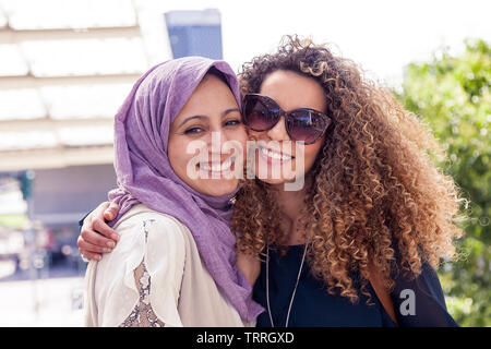 Due belle ragazze con borse per lo shopping a piedi su per le scale nel cuore della città Foto Stock