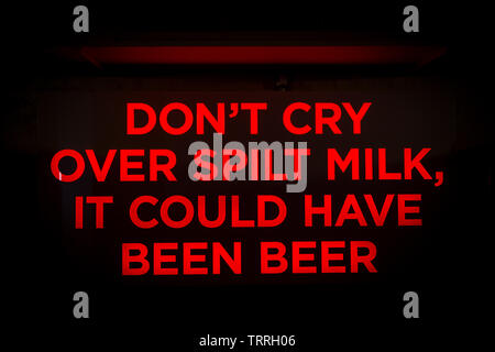 Insegna al neon dicendo non piangere sul latte versato, esso avrebbe potuto essere birra" in un cafe bar Foto Stock