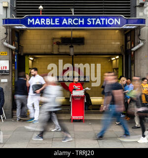 London, England, Regno Unito - 23 Aprile 2019: folle di pendolari a piedi passato l'ingresso alla stazione metropolitana di Marble Arch in ora di punta a Londra, in Oxford Street. Foto Stock
