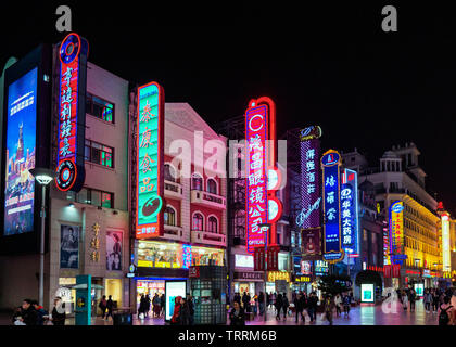 SHANGHAI, Cina - 12 MAR 2019 - Notte / sera vista scena di luci al neon, gli acquirenti e i pedoni lungo Nanjing East Road (Nanjing Dong Lu) pede Foto Stock