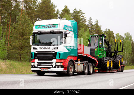 Raasepori, Finlandia. Il 24 maggio 2019. Colorato Scania R560 semi rimorchio di Kuljetusliike ho Huohvanainen Oy cale John Deere nuove macchine forestali su strada Foto Stock