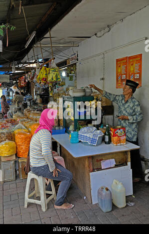 Jakarta, Indonesia - 18 maggio 2010: una giovane donna in attesa per il suo pasto per essere preparati a un foodstall su jalan pancoran in Chinatown Jakarta Foto Stock