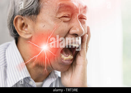 L'uomo anziano con gravi mal di denti e denti ipersensibili.denti cariati faccia dolorosa espressione. Foto Stock