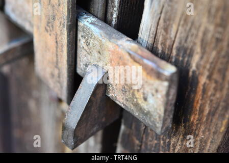 Close-up di un fermo di metallo su un cancello in legno. Foto Stock