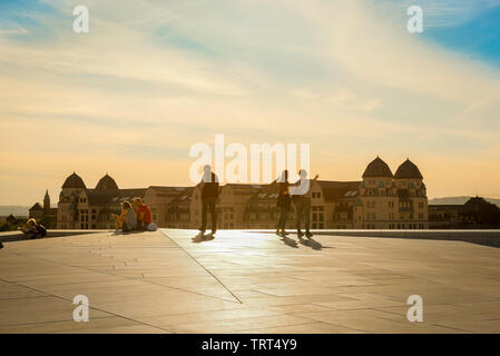 Il tetto del Teatro dell'Opera di Oslo, con vista su una serata estiva di turisti sul tetto del Teatro dell'Opera di Oslo (Operahuset) che guarda attraverso la città, Norvegia. Foto Stock