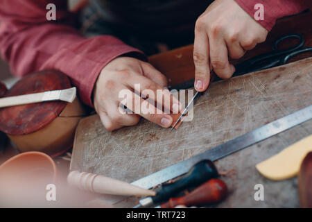 Tanner mette un disegno sulla pelle Foto Stock