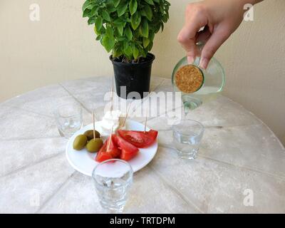 Raki servita con uno snack o meze come viene chiamato in Grecia. Foto Stock