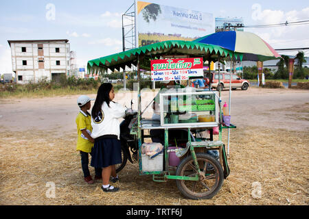Thailandese studenti un ragazzo e una ragazza acquistare cibo dal fornitore locale di carrello e sidecar in paglia marionette Festival presso Mahasarakham on gennaio 11, 2019 in Maha Sarakham, Foto Stock