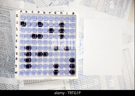 Corazzata laboratorio gioco fatto di cuvetta dello spettrofotometro in una scatola vuota e riempita nelle tabelle dei fogli di carta intorno ad esso Foto Stock