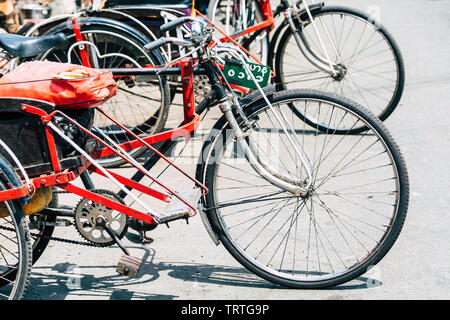 Yangon, Myanmar - Marzo 2019: vecchio vuoto Biciclette Risciò permanente sulla strada. Foto Stock