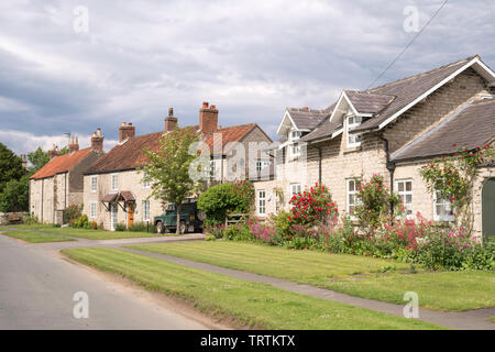 Una fila di case di pietra e case lungo la ferrovia strada di Slingsby, North Yorkshire, Inghilterra, Regno Unito Foto Stock