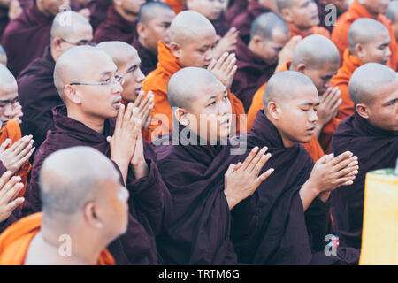 Yangon, Myanmar - Marzo 2019: i monaci buddisti durante la cerimonia ufficiale di Shwedagon pagoda. Alms cerimonia di consegna Foto Stock