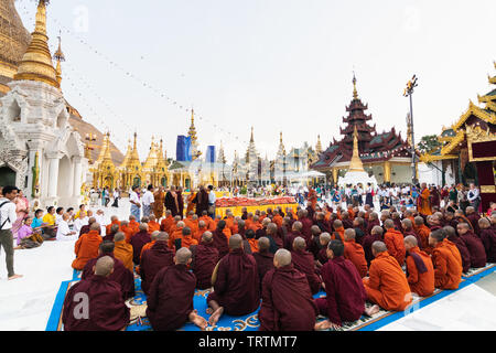 Yangon, Myanmar - Marzo 2019: i monaci buddisti durante la gazzetta alms dando cerimonia alla Shwedagon pagoda. Foto Stock