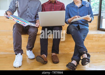 Lavoro di squadra di designer creativi a lavorare su un nuovo progetto e scegliere il campione di colore di campioni per colorazione di selezione sul digitale tavoletta grafica con gli strumenti di lavoro Foto Stock