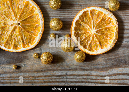 Composizione di natale con due secchi Arance e golden glitter palle su sfondo di legno - close-up Foto Stock