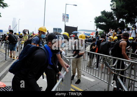 Hong Kong, Cina. 12 Giugno, 2019. Persone non identificate spostare barricate di metallo durante le proteste contro la legge in materia di estradizione in seno al consiglio legislativo area in Hong Kong Credit: Thomas Bertson/Alamy Live News Foto Stock