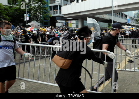 Hong Kong, Cina. 12 Giugno, 2019. Persone non identificate spostare barricate di metallo durante le proteste contro la legge in materia di estradizione in seno al consiglio legislativo area in Hong Kong Credit: Thomas Bertson/Alamy Live News Foto Stock