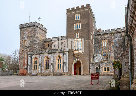 L'attraente facciata del medievale castello di Powderham con una torre centrale contenente un portale ad arco che dà accesso alla sala grande Foto Stock