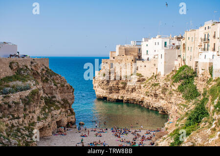 Vista panoramica sullo skyline della città con case bianche e la spiaggia cittadina, sulle rocce, regione Puglia, Italia, Europa. Il concetto di viaggio con sfondo blu del mare Foto Stock