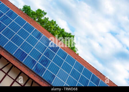 Angolo olandese vista di una casa tedesca tetto con pannelli solari sotto un cielo blu. Foto Stock