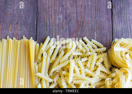 Diversi tipi di diversi di pasta su sfondo di legno Foto Stock