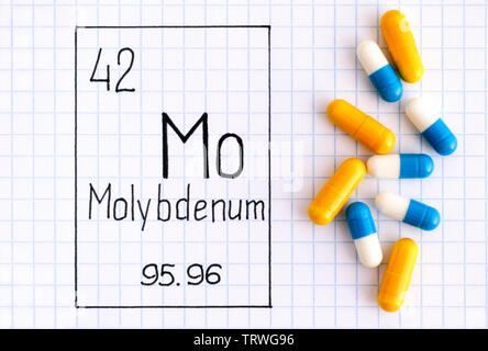 La grafia elemento chimico molibdeno Mo con alcune pillole. Close-up. Foto Stock