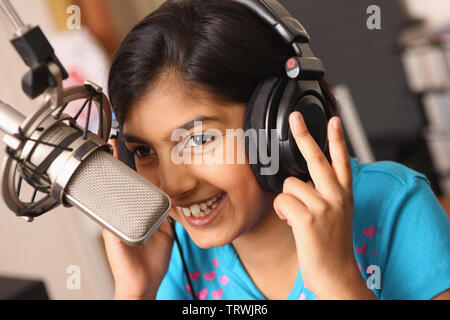 Ragazza disc jockey parlando in un microfono Foto Stock