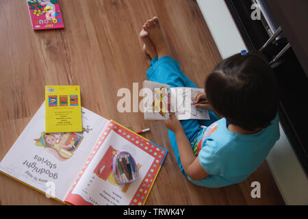 Elevato angolo di visione di una ragazza di colorazione in un libro Foto Stock