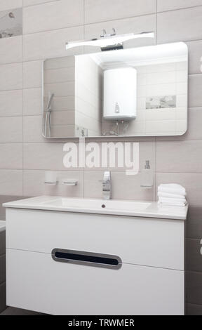 Epmty interni minimalisti sfondo, bagno di moderno appartamento, primo piano dello specchio, toccare e bacino in colori chiari, nessuno, con copia spazio, verti Foto Stock