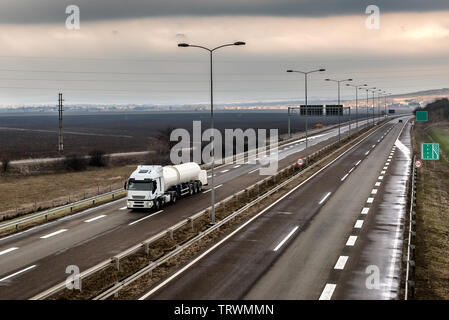 Carrello serbatoio su un avvolgimento Autostrada attraverso il paesaggio rurale Foto Stock