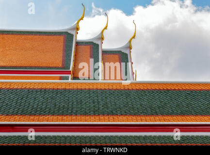 Tetti colorati del tempio di Bangkok su uno sfondo di cielo blu. Foto Stock