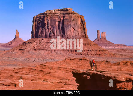 Navajo uomo a cavallo nel parco tribale Navajo, Arizona e Utah. Arenaria colorata buttes. Foto Stock