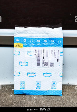 Babilonia, New York, Stati Uniti d'America - 18 Aprile 2019: la perfezione del Amazon package a sinistra sulla parte anteriore stoop lasciato fuori in aperto per tutti a vedere. Foto Stock