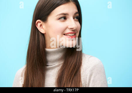 Testa e la spalla ritratto di una giovane donna caucasica isolata su sfondo blu Foto Stock
