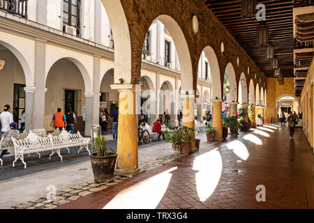 I pedoni a piedi lungo la Plaza de las Armas e il Portales de Veracruz nel centro storico della città di Veracruz, Messico. La zona è la piazza principale di Veracruz. Foto Stock